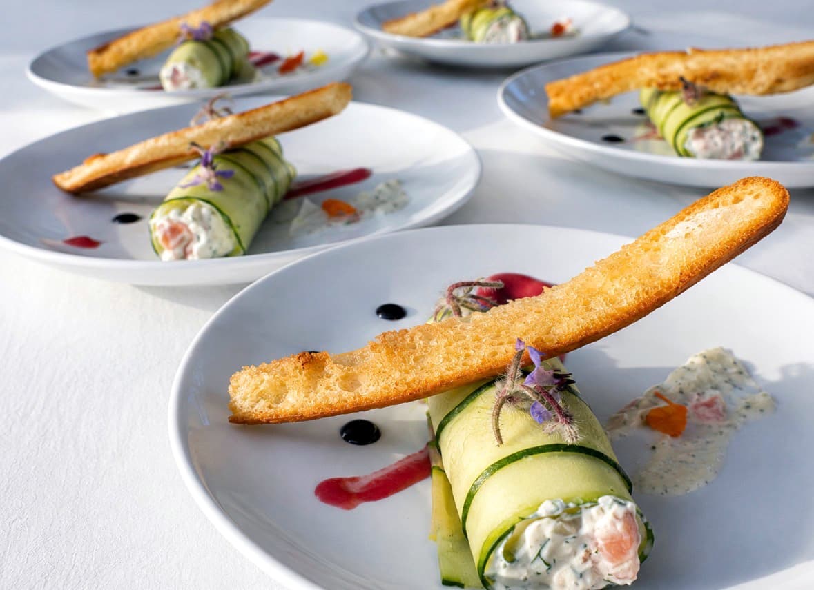 Assiettes blanches avec un rouleau de concombre garni et un croustillant doré