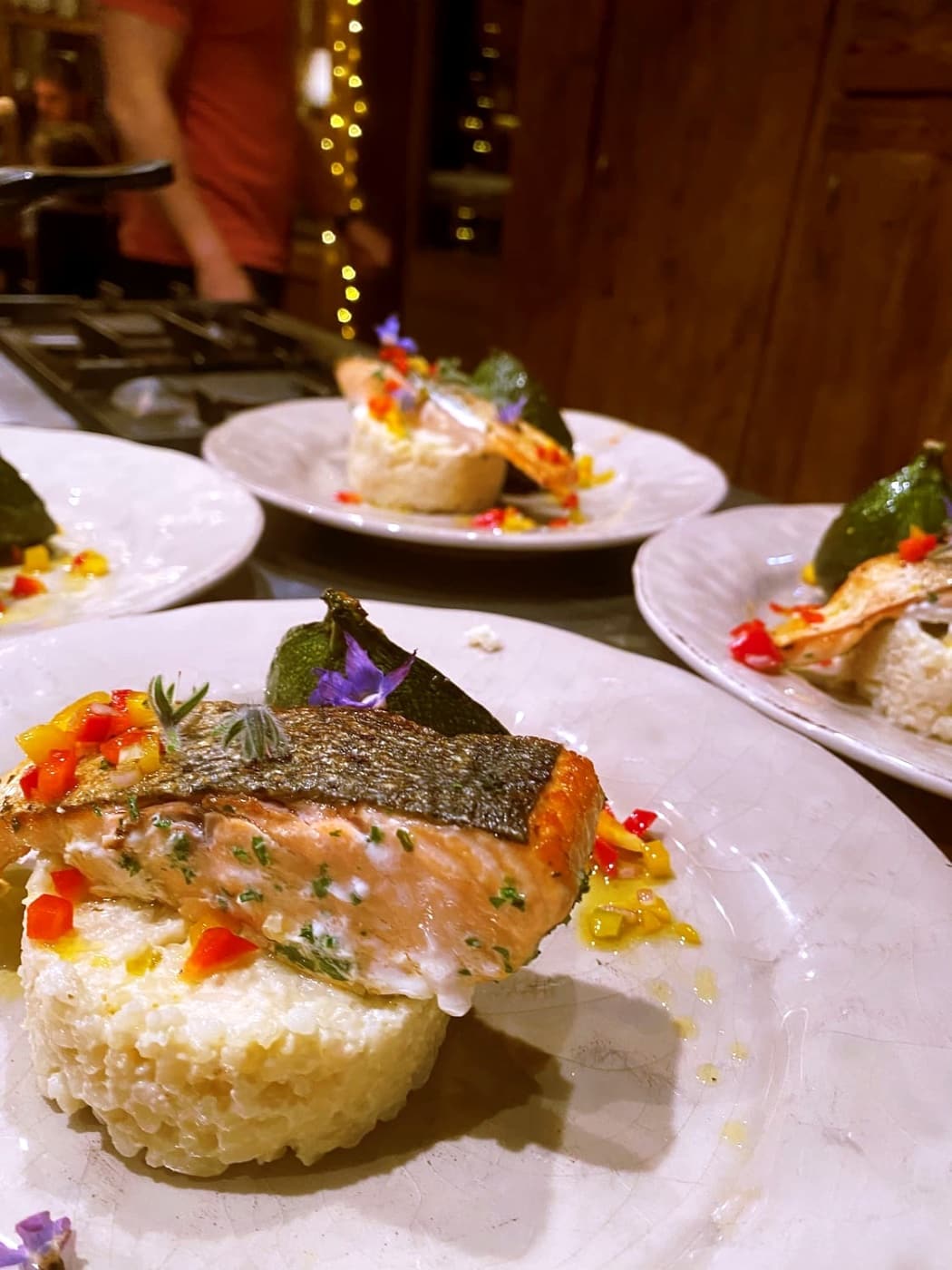 Assiette dressée avec un poisson à la peau croustillante, des herbes et de petits dés de légumes