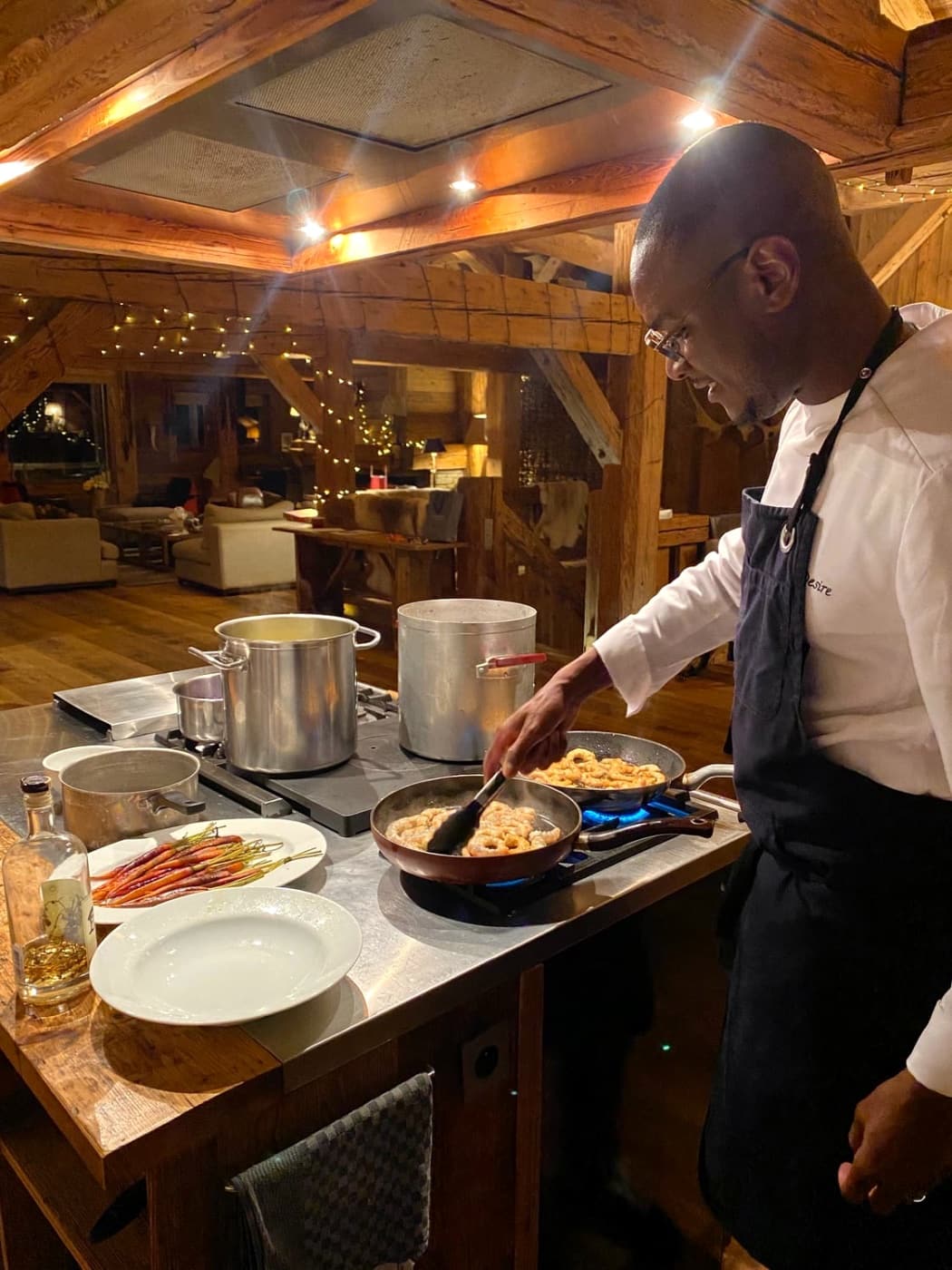 Chef Kévin en cuisine dans un chalet en bois, une poêle sur le feu