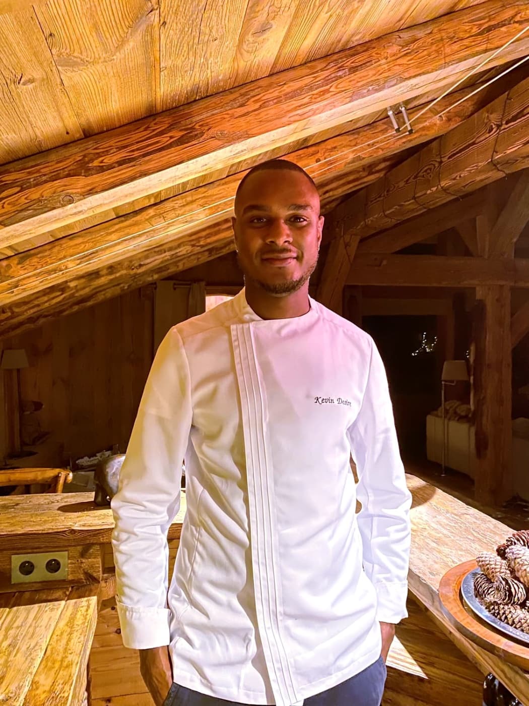 Portrait souriant de Chef Kévin en veste de cuisine blanche